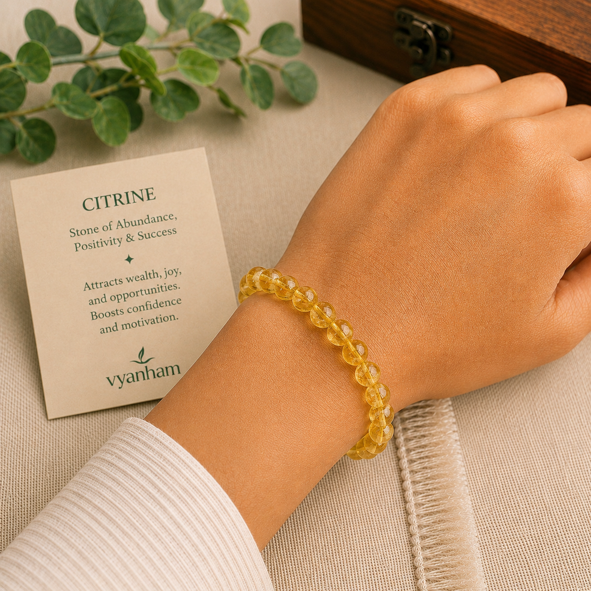 Citrine bracelet worn on a wrist beside the Vyanham intention card